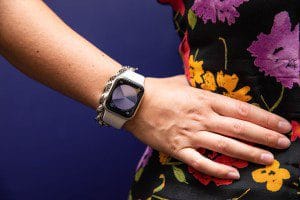 Woman in floral dress with hand on hip modeling Apple watch SE (2022)