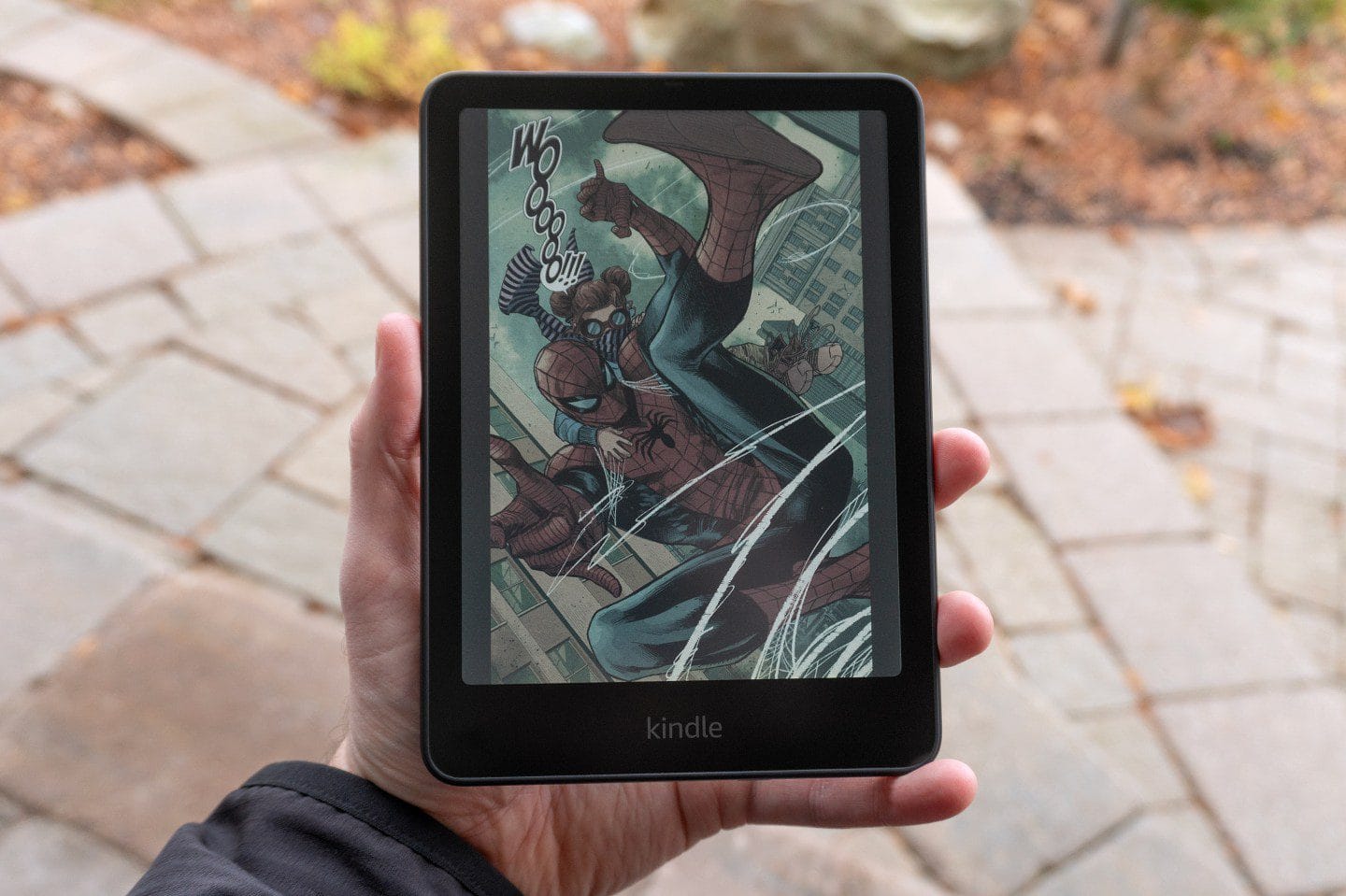 A hand touching the Kindle Paperwhite screen.